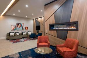 a lobby with a waiting room with a fireplace at Delta Hotels by Marriott Grand Rapids Airport in Grand Rapids