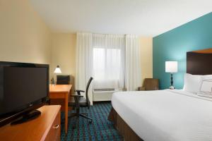 Fairfield Inn & Suites Dallas Mesquite في ميسكوايت: غرفة فندقية فيها سرير ومكتب وتلفزيون