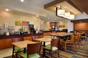 メスキートにあるFairfield Inn & Suites Dallas Mesquiteのテーブルと椅子のあるレストラン、キッチンが備わります。