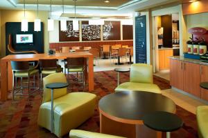 a restaurant with a bar with yellow chairs and tables at TownePlace Suites by Marriott Saginaw in Saginaw