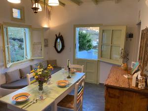 a kitchen and dining room with a table with flowers on it at Villa Meltemi in Arnados