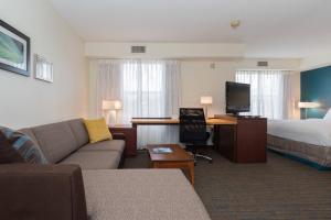 Habitación de hotel con sofá, cama y escritorio. en Residence Inn by Marriott Lake Norman, en Huntersville