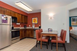 eine kleine Küche mit einem Tisch, Stühlen und einem Bett in der Unterkunft Residence Inn by Marriott Lake Norman in Huntersville