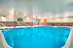 una piscina en un hotel con sillas y mesas en Fairfield Inn & Suites by Marriott Houston Energy Corridor/Katy Freeway, en Houston