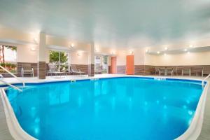 a pool in a hotel with chairs and tables at Sonesta Essential Houston Energy Corridor in Houston
