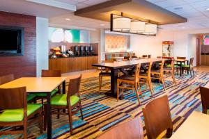 a dining room with tables and chairs in a restaurant at Fairfield Inn & Suites by Marriott Atlanta Perimeter Center in Atlanta