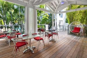 a patio with tables and chairs on a deck at The Saint Hotel Key West, Autograph Collection in Key West