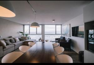 - un salon avec une grande table et des chaises en bois dans l'établissement Duplex frente al mar, à Monte Hermoso