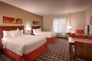 a hotel room with two beds and a television at TownePlace Suites Boise West / Meridian in Meridian