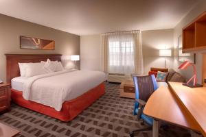 a hotel room with a large bed and a desk at TownePlace Suites Boise West / Meridian in Meridian