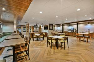 a restaurant with tables and chairs and a bar at Fairfield Inn & Suites by Marriott Kalamazoo in Kalamazoo