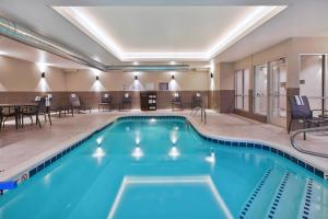 - une piscine dans une chambre d'hôtel avec des chaises et des tables dans l'établissement Fairfield Inn & Suites by Marriott Kalamazoo, à Kalamazoo