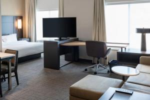 Habitación de hotel con cama y escritorio con TV. en Residence Inn by Marriott Wilkes-Barre Arena en Wilkes-Barre