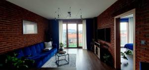 a living room with a blue couch and a brick wall at Apartmán Jako doma in Olomouc