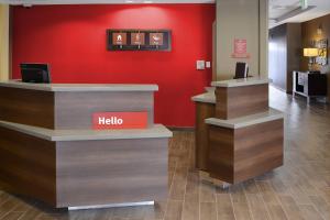 a hello counter in a lobby with a red wall at TownePlace Suites by Marriott Houston Galleria Area in Houston
