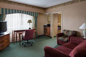 a hotel room with a couch and a desk and a chair at Radisson Hotel Cedar Rapids in Cedar Rapids