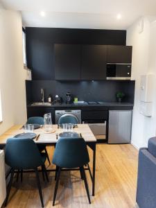 タルブにあるAppartement - Le Petit Loft -のテーブルと椅子のあるキッチンとダイニングルーム