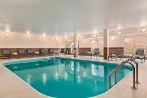a pool in a hotel lobby with chairs and tables at Fairfield Inn & Suites Houston Humble in Humble