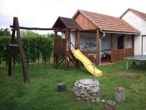 a playground with a slide and a house at Veronika Guesthouse in Drávatamási