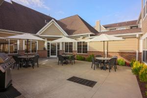 a patio with tables and chairs and umbrellas at Residence Inn Deptford in Almonesson