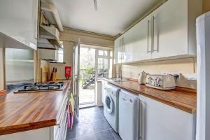 a kitchen with a washer and dryer on a counter at 2 bed flat - SW London with parking in Teddington