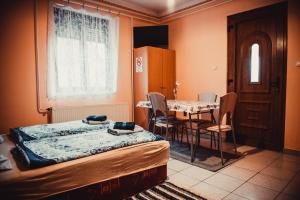 a bedroom with a bed and a table with chairs at Veronika Guesthouse in Drávatamási