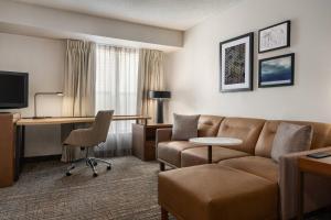 a hotel room with a couch and a desk at Residence Inn Deptford in Almonesson