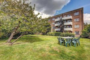 a table and chairs in a yard in front of a building at 2 bed flat - SW London with parking in Teddington