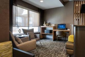 a living room with a couch and a desk with a computer at SpringHill Suites Danbury in Danbury