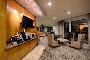 a hotel room with a waiting area with a television at Courtyard by Marriott New Braunfels River Village in New Braunfels