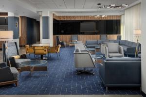 Courtyard by Marriott Indianapolis Plainfield في بلينفيلد: غرفة انتظار مع كراسي كنب وتلفزيون