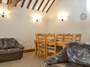 a living room with a dining room table and chairs at Littlewood Barn - Ukc3737 in Bawdeswell