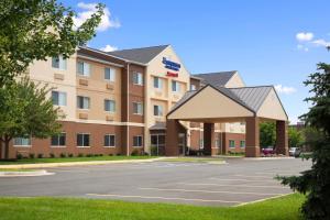an exterior view of a hotel with a parking lot at Fairfield Inn & Suites Lansing West in Delta Center Township