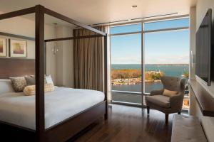 ein Schlafzimmer mit einem Bett und einem großen Fenster in der Unterkunft Buffalo Marriott at LECOM HARBORCENTER in Buffalo