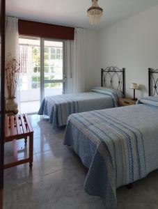 1 dormitorio con 2 camas y ventana en Casa Camila en Portonovo, en Sanxenxo