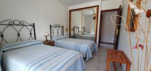 1 dormitorio con 2 camas y espejo en Casa Camila en Portonovo, en Sanxenxo