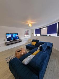 un salon avec un canapé bleu et une télévision dans l'établissement Luxury 2 Bed, 2 Bath Apartment - The Quays, à Manchester