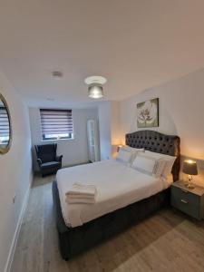 - une chambre avec un grand lit et une chaise dans l'établissement Luxury 2 Bed, 2 Bath Apartment - The Quays, à Manchester