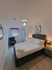 ein Schlafzimmer mit einem großen Bett und einem Stuhl in der Unterkunft Luxury 2 Bed, 2 Bath Apartment - The Quays in Manchester