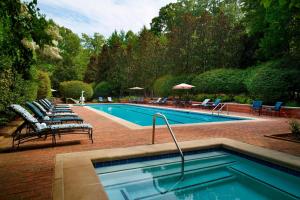 a swimming pool with lounge chairs next to at Westfields Marriott Washington Dulles in Chantilly