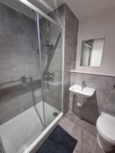 ein Bad mit einer Dusche, einem WC und einem Waschbecken in der Unterkunft Luxury 2 Bed, 2 Bath Apartment - The Quays in Manchester