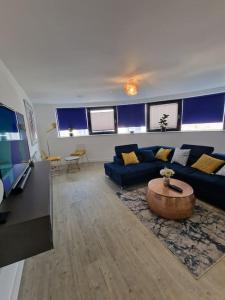 - un salon avec un canapé bleu et une table dans l'établissement Luxury 2 Bed, 2 Bath Apartment - The Quays, à Manchester