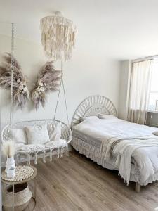 a bedroom with a bed and a chair and a chandelier at La Rossa Sopot Apartaments in Sopot