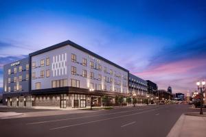 a large white building on a city street at night at Courtyard by Marriott Lansing Downtown in Lansing