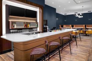 a bar in a restaurant with stools at Courtyard by Marriott Lansing Downtown in Lansing