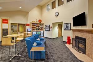 a living room with a fireplace and a tv at TownePlace Suites Detroit Dearborn in Dearborn