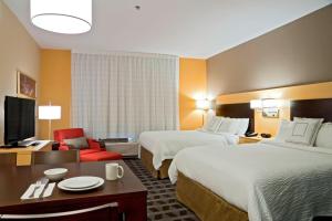 a hotel room with two beds and a desk at TownePlace Suites by Marriott Dodge City in Dodge City