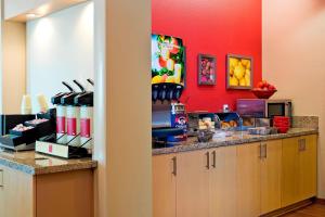 a kitchen with a counter and a red wall at TownePlace Suites by Marriott Dodge City in Dodge City