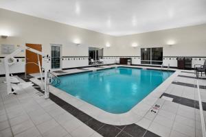 een groot zwembad met blauw water in een gebouw bij Fairfield Inn & Suites by Marriott Marietta in Marietta