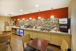 a kitchen with a counter and a table and chairs at TownePlace Suites Detroit Dearborn in Dearborn